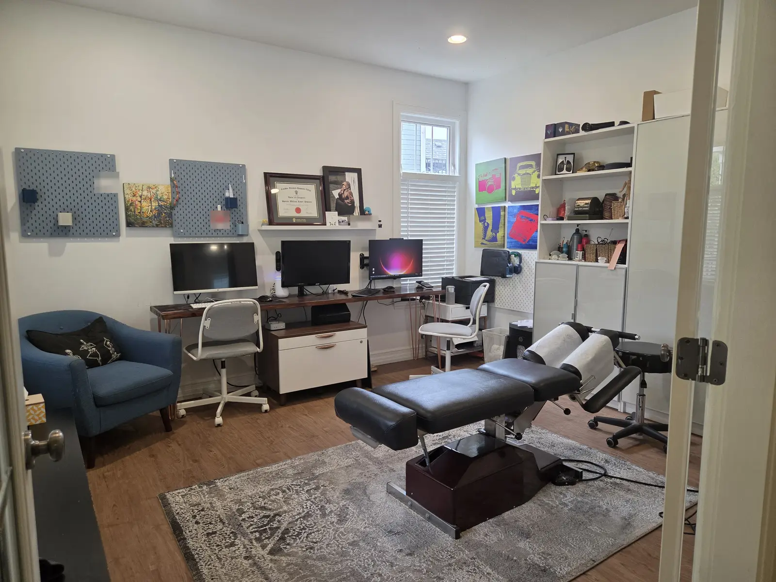 The treatment room, with a treatment table, a blue armchair and a desk